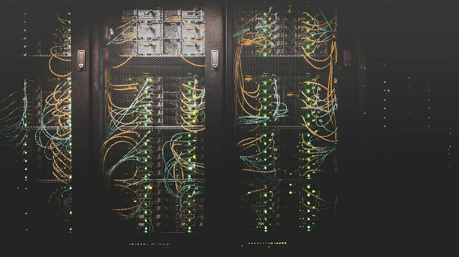 Server racks wired with cables in a dark data center